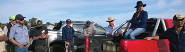 A group of people chatting amongst themselves in a parking lot