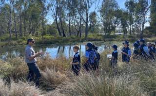 A photograph of an excursion group at a riverside